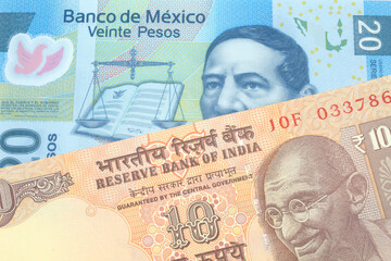 An orange, Indian ten rupee bill, close up with A blue twenty peso note from Mexico