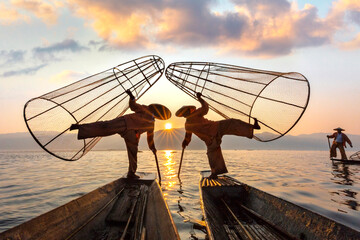 Fishermen known as leg rowers in silhouette at the sunrise, Inle Lake, Myanmar