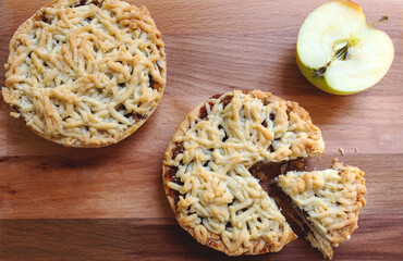 Pieces of delicious apple pie on wooden background