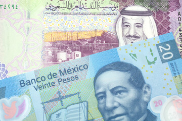 A colorful five riyal bank note from Saudi Arabia with a blue twenty Mexican peso bank note close up in macro