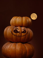 Halloween Pumpkins With full moon and moonlight.  Orange, brown Pumpkin with a painted scary face.