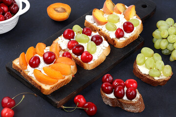 Diet fruit bruschetta with cottage cheese, peaches, grapes and cherries, a healthy breakfast with ingredients. The concept of healthy and natural food, lifestyle, flat lay, place for text