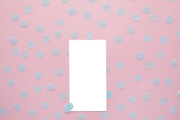 Empty white card and blue confetti on pink background. Mockup template. top view. Blank flyer