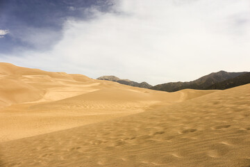 Fototapeta na wymiar sand dunes with mountain and clouds