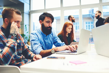 Group of design professionals working together with laptop computer as a team in the office. Casual dressed business people looking for staff job posting on the site. Start sharing successful business