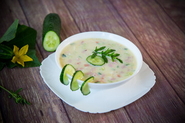 summer cucumber soup with vegetables on a wooden table