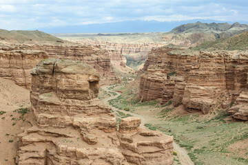 a canyon with a river and small vegetation in Central Asia