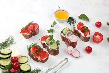 Dietary bruschetta with cheese, cucumber, radish and red fish, healthy breakfast with ingredients. Healthy and natural food concept, lifestyle, flat lay, place for text
