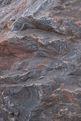 Naklejka premium Rough surface of a old brown and gray granite boulder. Abstract pattern of raw granite. Stone texture for background use. 