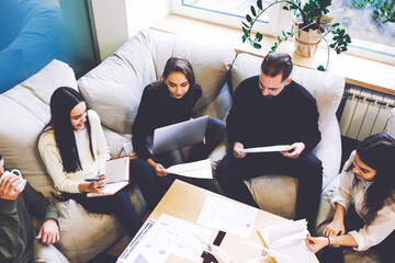 Male and female financial experts checking accounting reports of corporation via modern laptop computer and wireless connection to internet during informal meeting conference in coworking space