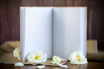 bouquet of beautiful white roses and blank notebook