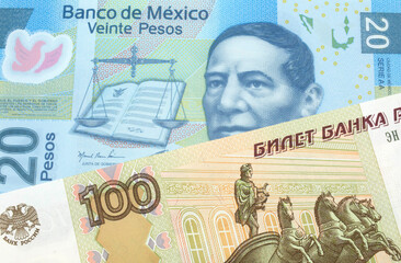 A close up image of a one hundred Russian ruble bank note close up with a twenty Mexican peso bank note