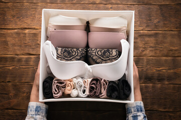 Woman is packing a lingerie in a storage box close up.