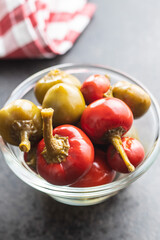 Round chili peppers. Green and red pickled peppers.