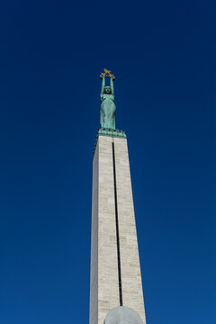 Copper figure of Liberty at the top of the Freedom Monument in Riga, Latvia. It is a 9 meters woman lifting three gilded stars, symbolizing the districts of Latvia: Vidzeme, Latgale and Courland.