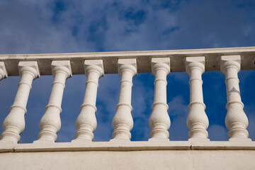 white cement railing on a background of  sky with clouds