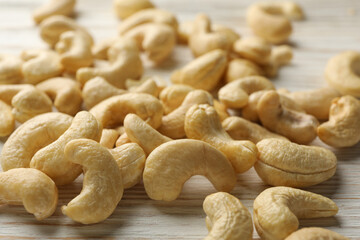 Tasty cashew nuts on white wooden background. Vitamin food