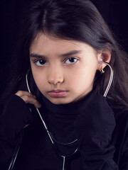 Serious little girl isolated on black background with stethoscope. Stay home. Stop covid-19. Virus protection equipment. Quarantine. Girl plays a doctor.  stethoscope and girl