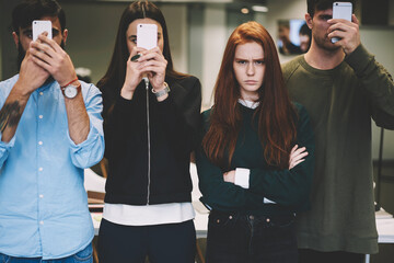 Angry teen hipster girl disappointed about being alone as her friends active in social networks...