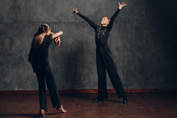 Couple in black dress dancing in ballroom dance rumba.