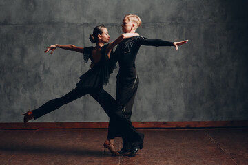 Fototapeta na wymiar Couple in black dress dancing ballroom dance rumba.