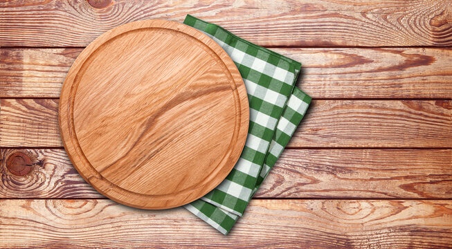 Empty vintage pizza board and napkin on planks.