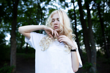 Closeup portrait of a beautiful young blonde woman with closed eyes in the park, the concept of beauty and health.