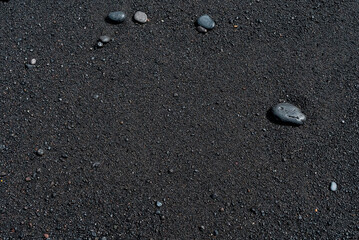 Black sand beach with pebble macro photography. Silky black beach texture. Minimalistic black...
