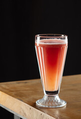 Glass of grapefruit juice on a wooden table. Shallow depth of field