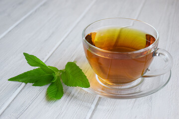 Cup of black tea on a light wooden background