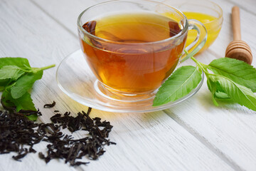 Cup of black tea on a light wooden background