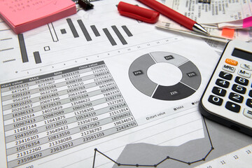 business office desk closeup - financial reports, analysis and accounting, set of documents, tables and graphs, various items for bookkeeping, calculator