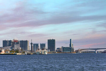 Obraz premium Seascape of boats moored at Harumi Passenger Terminal on Tokyo Bay in front of the buildings of Ariake island at sunset.