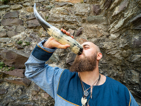 Portrait of a young warrior drinking from a Viking horn