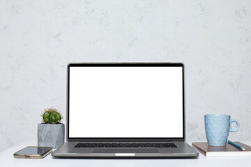 Laptop with blank empty screen on white table in interior. mockup