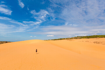Fototapeta na wymiar Happy woman on Red sand dunes in Vietnam