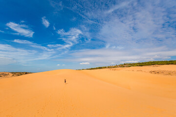 Fototapeta na wymiar Happy woman on Red sand dunes in Vietnam