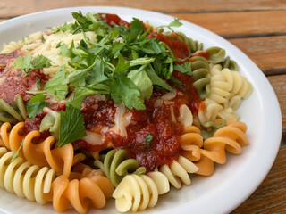 Colorful pasta with tomato sauce and cheese
