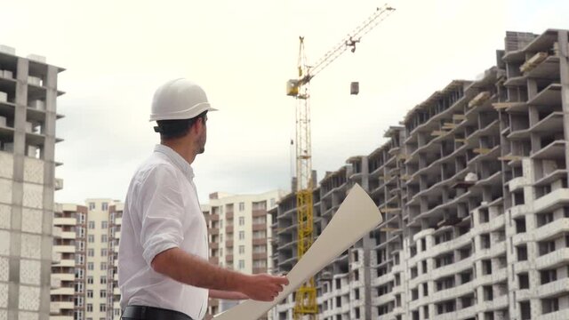 Architect or engineer working, browsing building project of construction site with blueprint plan