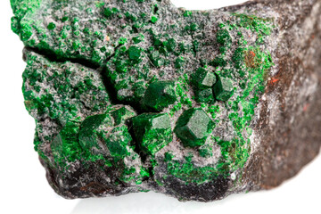 macro stone mineral uvarovite on a white background