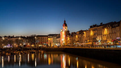 Fototapeta na wymiar Panoramic view of the grosse horloge of La Rochelle at blue hour with beautiful illuminated city lights