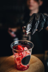 The bartender makes a cocktail - adds sweet syrup to the glass - a refreshing drink