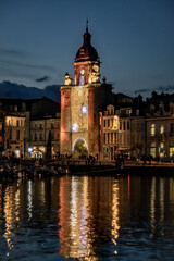 Fototapeta na wymiar the grosse horloge of La Rochelle at night with beautiful illuminated city lights. portrait format