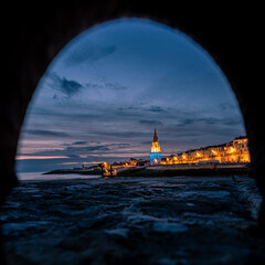 the famous lanterne tower of La Rochelle at blue hour with beautiful city light. view in the frame
