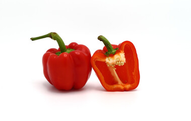 One red ripe sweet pepper and one half pepper on a light background. Natural product. Natural color. Close-up.