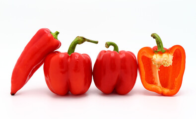 Few red ripe sweet peppers and one pepper in a cut on a light background. Natural product. Natural color. Close-up.
