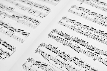 Fragment of sheet with music notes for the piano. Close-up. Selective focus.