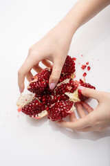Woman hands with pomegranate seeds. Selective focus. Red pomegranate is torn with two female hands...