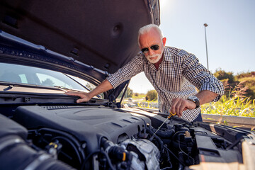 Fototapeta na wymiar Senior man check oil in car.