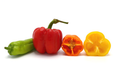 Composition of several sweet peppers and their halves of different colors on a light background. Natural product. Natural color. Close-up.